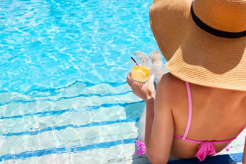Woman in hotel pool with cocktail